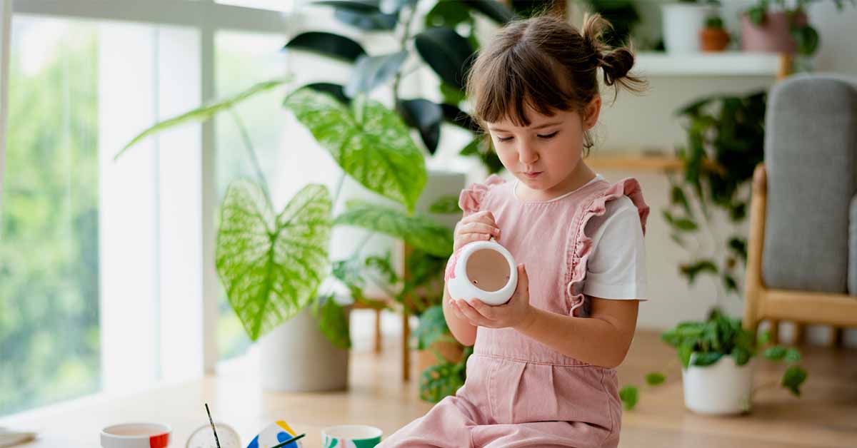 Kid painting a plant pot home diy hobby