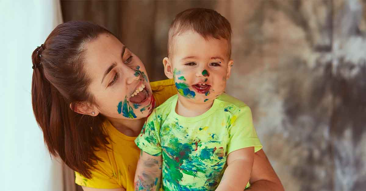 The mother with son painting a big paper with their hands