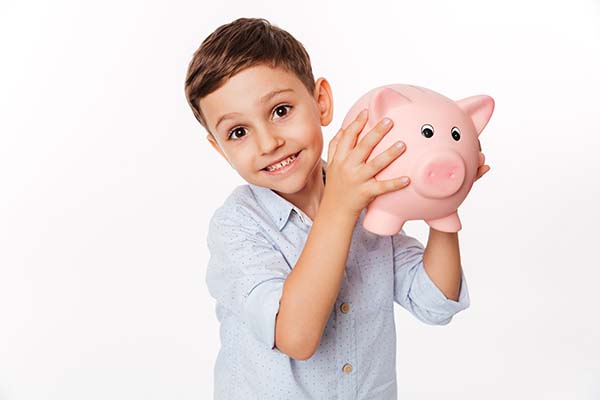 cheerful cute little kid with piggy bank