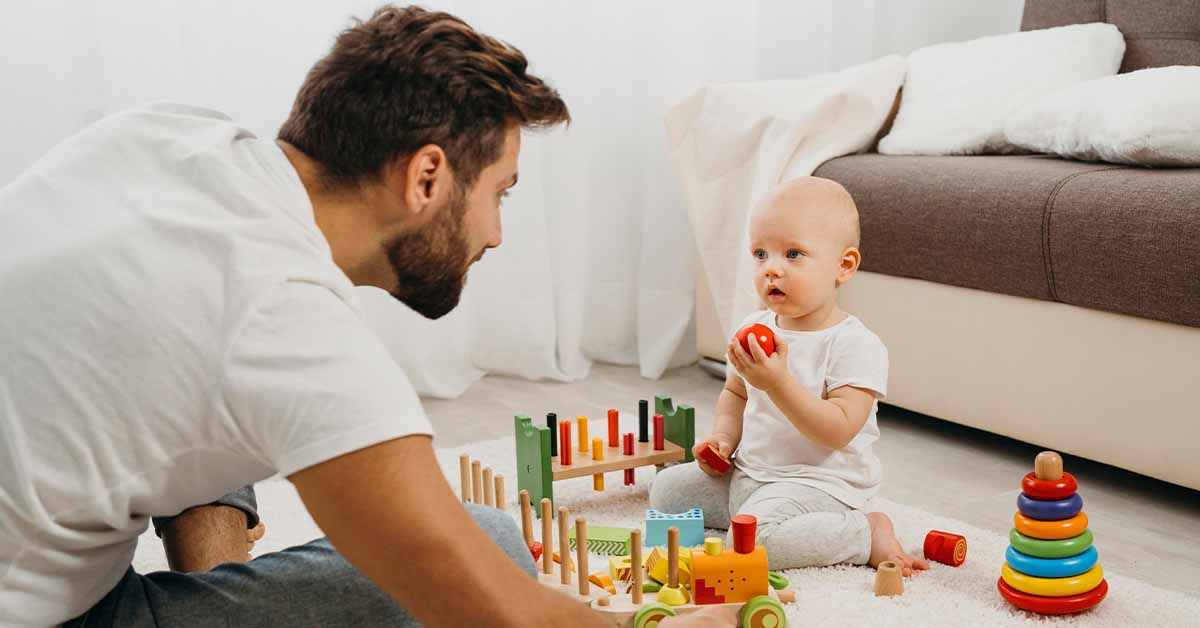 Father teaching baby to play with toys