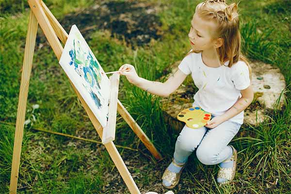 Kids painting ideas: Cute little girl painting in a park