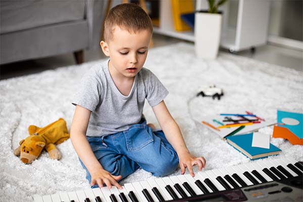 Little boy learning how to play the piano