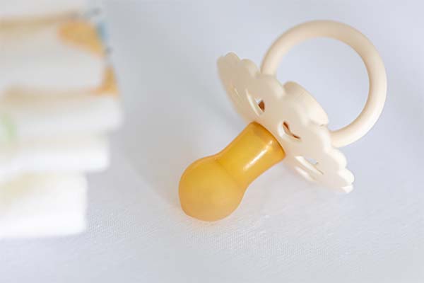 Bay shower gifts: Baby pacifier and diapers in the crib closeup