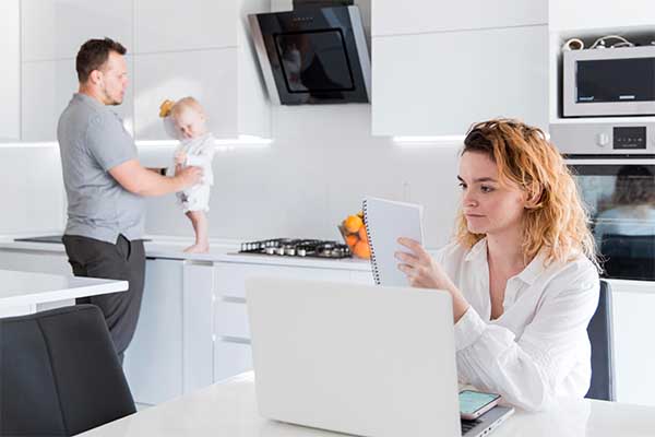 Father playing with baby and mother having me time