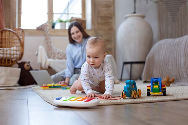smiley woman and baby on floor