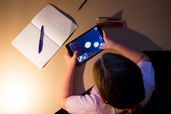Children's toys: Girl playing tablet game in evening