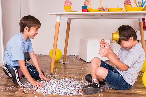 Happy friends enjoying party with confetti and messy play