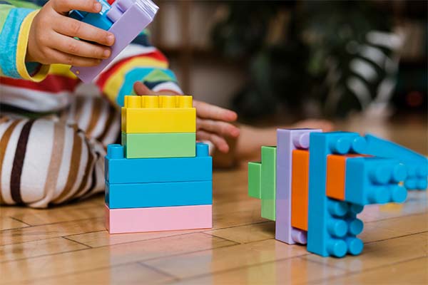 little boy playing with  LEGO building toys