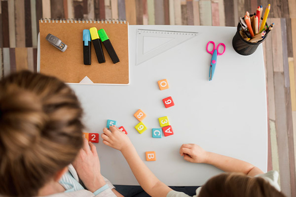 child and tutor learning about numbers and letters