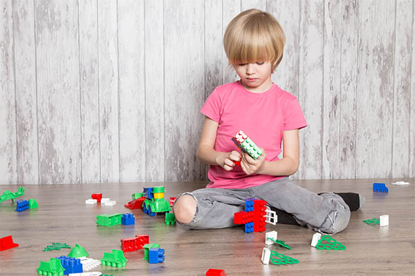 A boy is playing with lego 