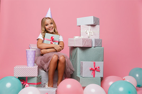 a happy little girl in a birthday hat