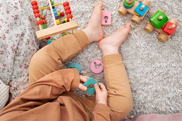 little kid holding wooden Safe and Non-Toxic Toys