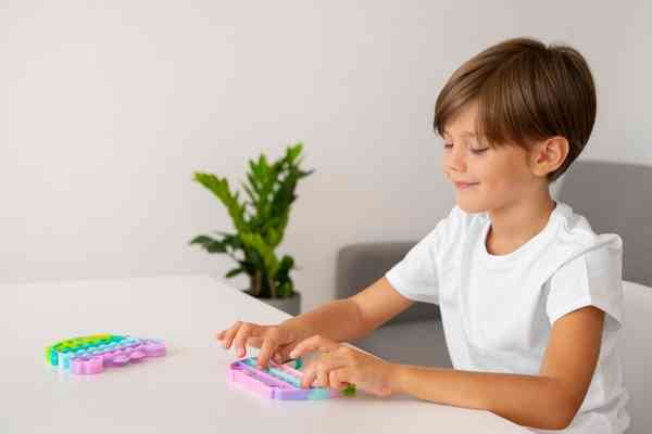 Young boy playing with fidget trending toy at home